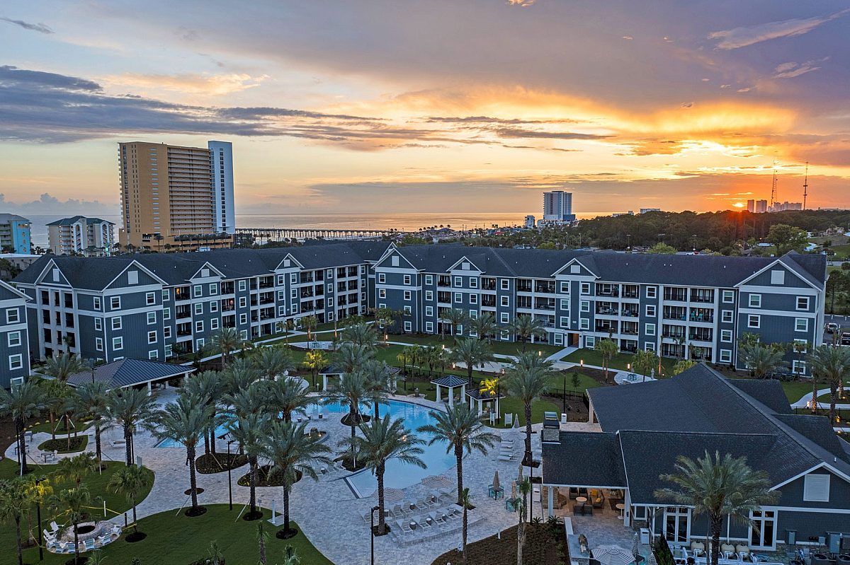 top view of an apartment complex with swimming pool and palm trees