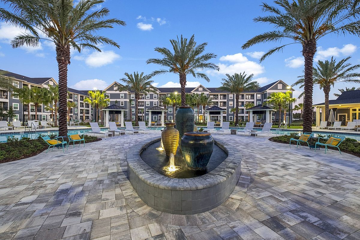 apartment complex front view with beach chairs, swimming pool, and fountain
