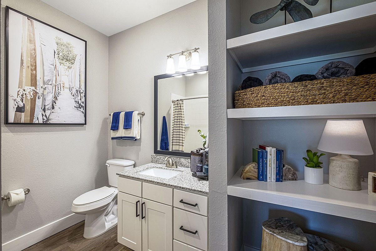 furnished bathroom mirror, picture frame and basket of towels