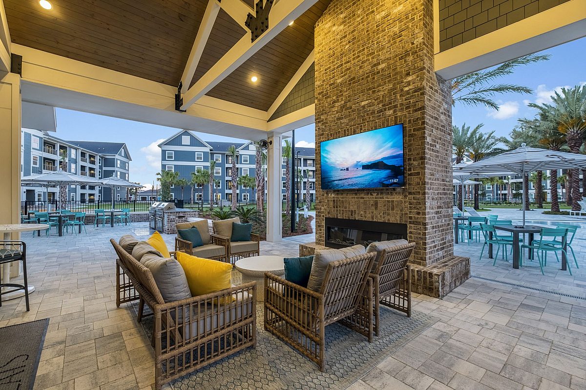 fireplace area with sofa and tv near the swimming pool